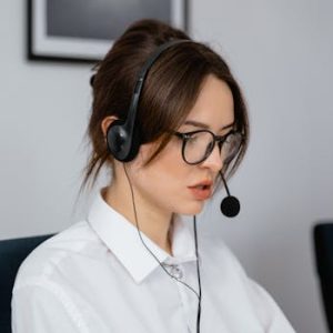 pexels-photo-7709224-7709224 Focused woman working in a call center with a headset, providing customer support and communication services.